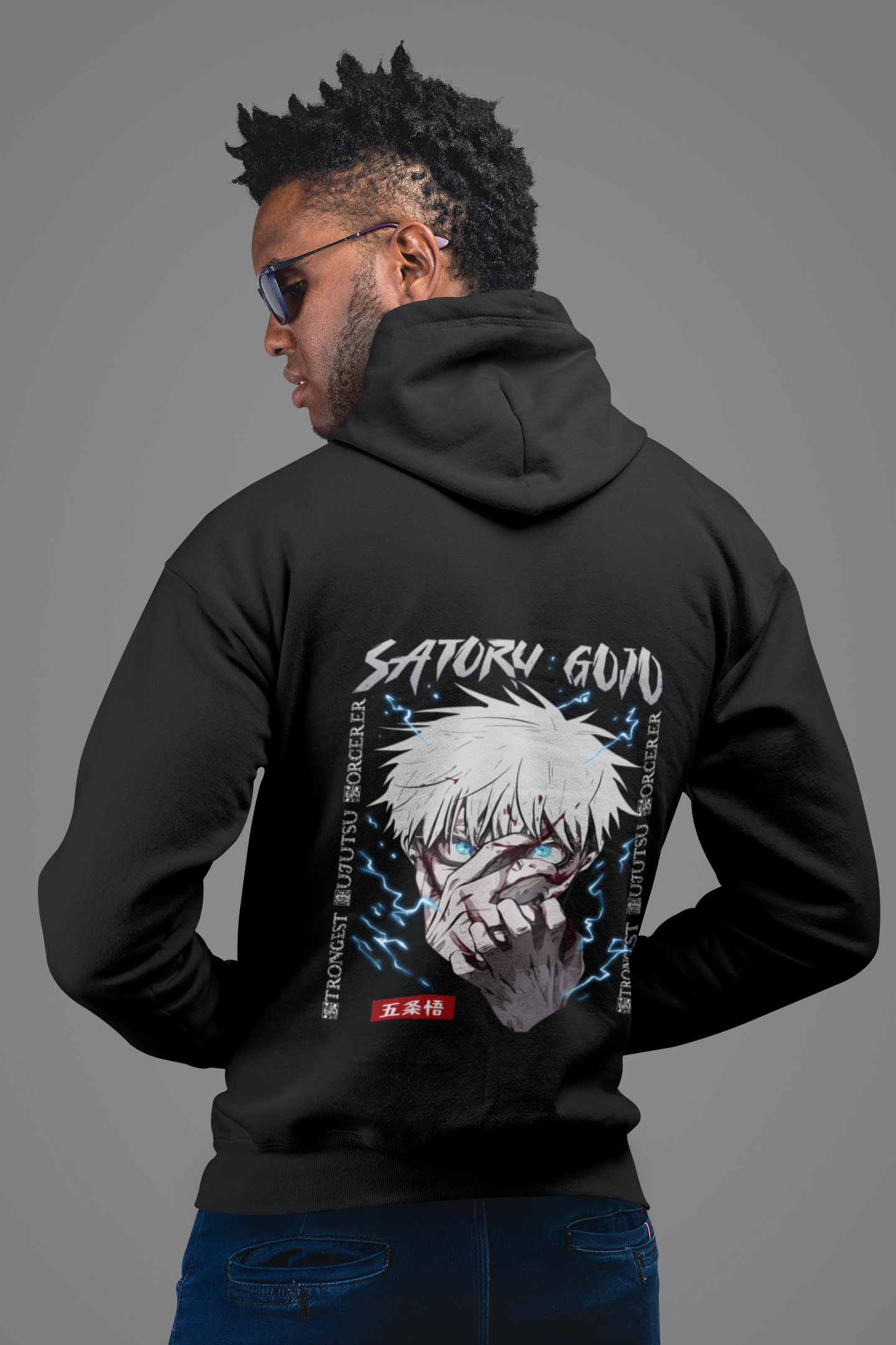 a man wearing a black hoodie with a picture of an anime character on it