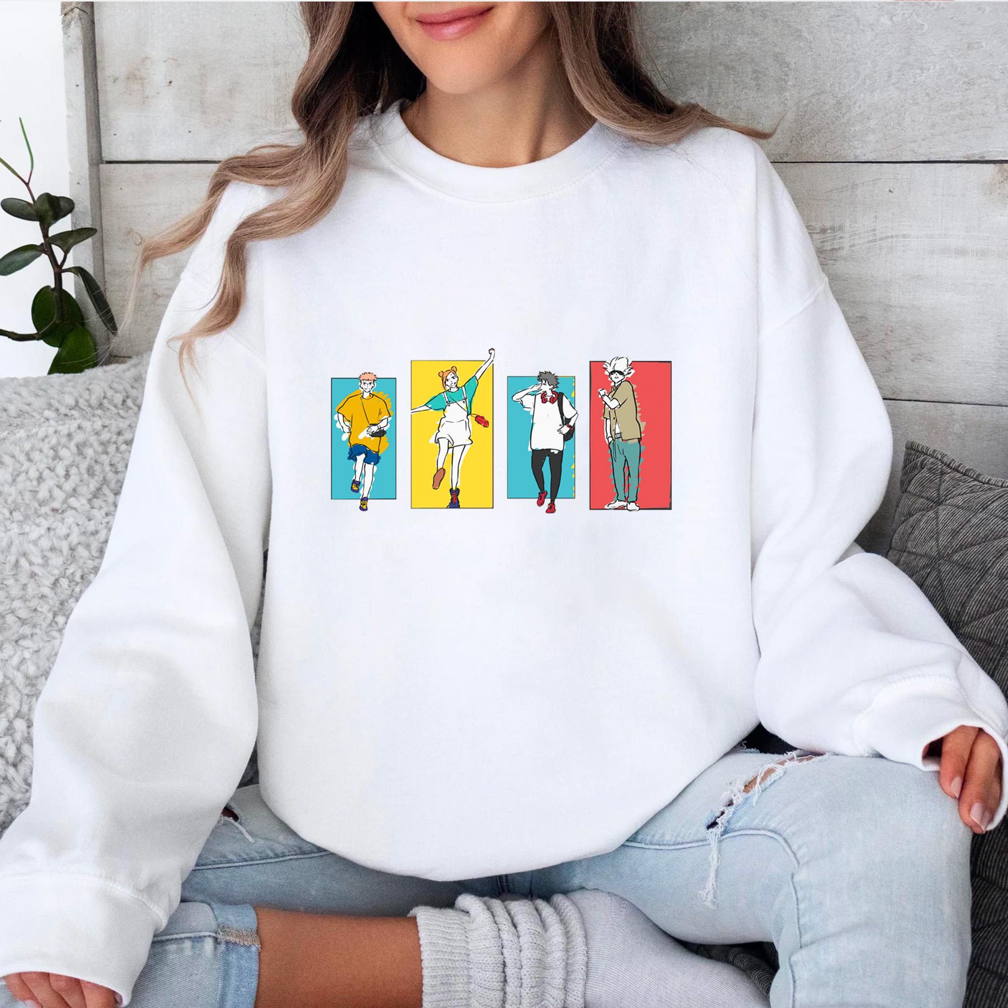 a woman sitting on a couch wearing a white sweatshirt with cartoon characters on it